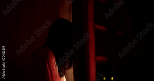 Horror scene of a person Mysterious Figure Asian ghost woman creepy have long hair looking to camera in Nighttime Scene with Eerie Red Light, festival Halloween