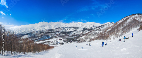 A stunning view of the cloud-covered Hakuba Sanzan mountain range from a ski slope (Tsugaike Kogen, Hakuba, Nagano, Japan)