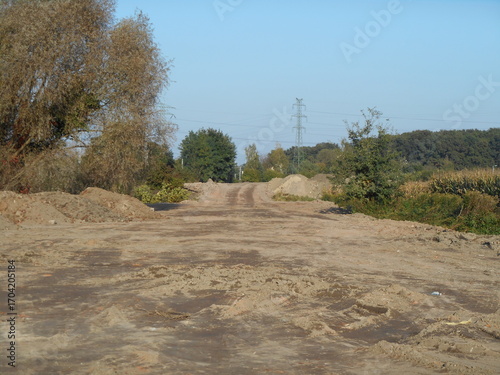 Flat terrain, newly leveled. Trees in the background.