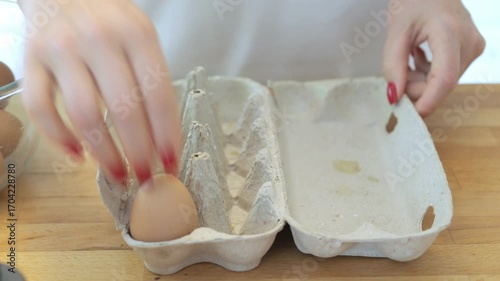 Person is holding a carton of eggs. The carton is open and the eggs are inside