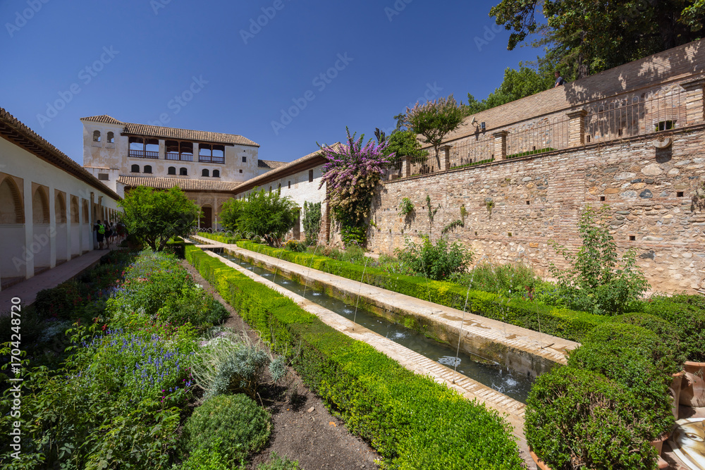 Fototapeta premium Alhambra Gardens showcasing moorish architecture and lush vegetation in Granada, Spain