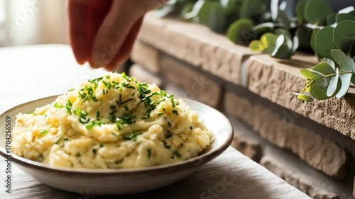 General Food & Beverage Sprinkling Fresh Herbs onto a Plate of Mashed Potatoes