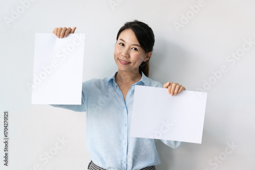 Asian business woman showing blank poster paper with copy space for design or advertising