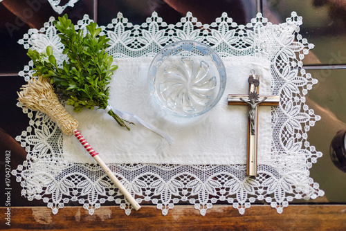 Fotografie Religious wedding blessing cross with candle and holy water brush on white cloth