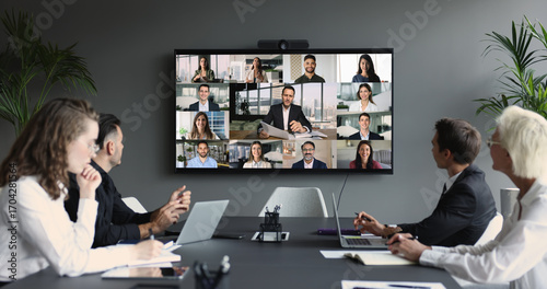 Tableau sur toile Group of diverse businesspeople gathered in boardroom engaging in videoconferenc