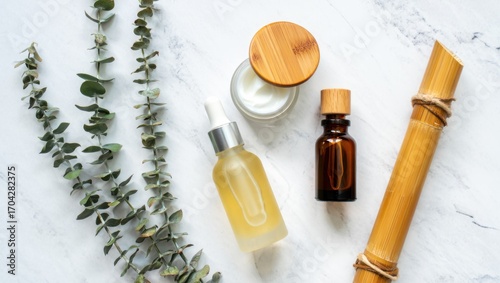 Aesthetic Collection of Natural Skincare Products Featuring Essential Oils, Creams, and Fresh Eucalyptus Leaves on White Marble Background