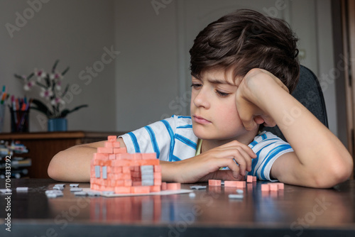 Fotografía Frustrated child struggling with building blocks at home