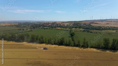 Aerial panorama view of Industrial Harvest of a large agriculture wheat field on a sunny day in Germany