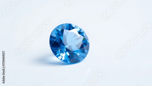 A single brilliant oval cut blue topaz gemstone sparkling with light against a clean white background