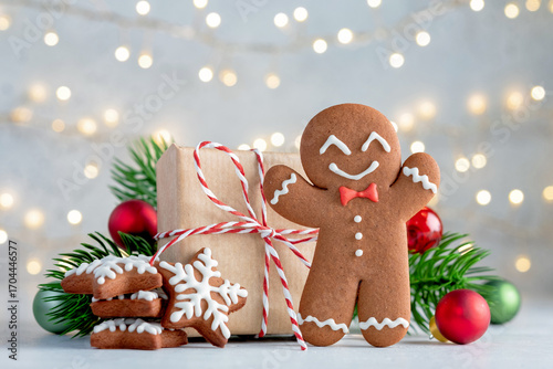 A gingerbread man is standing next to a box of cookies