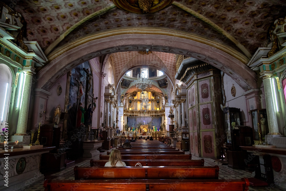 Naklejka premium Interior of Oratorio de San Felipe Neri with vaulted ceiling, dome, altar and seated visitor in San Miguel de Allende