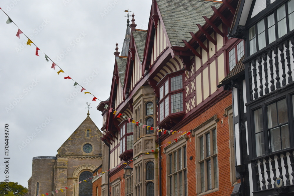 Obraz premium Colourful bunting bringing the high street of Shrewsbury to life lined up with traditional Tudor style buildings and churches One chapel in the town centre has been converted into a boutique Spa hotel