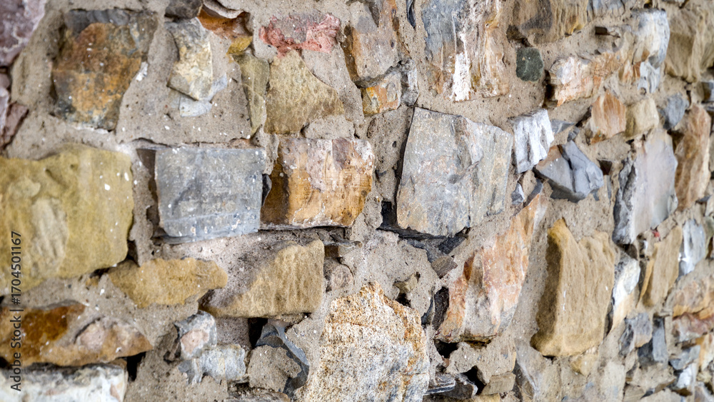 Obraz premium Close-up of a natural stone wall showing textured masonry and detailed stone patterns