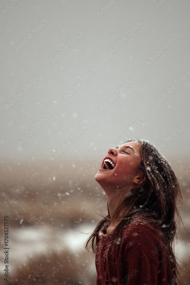 Fototapeta premium joyful girl gazes up with pure wonder as snowflakes gently fall around her