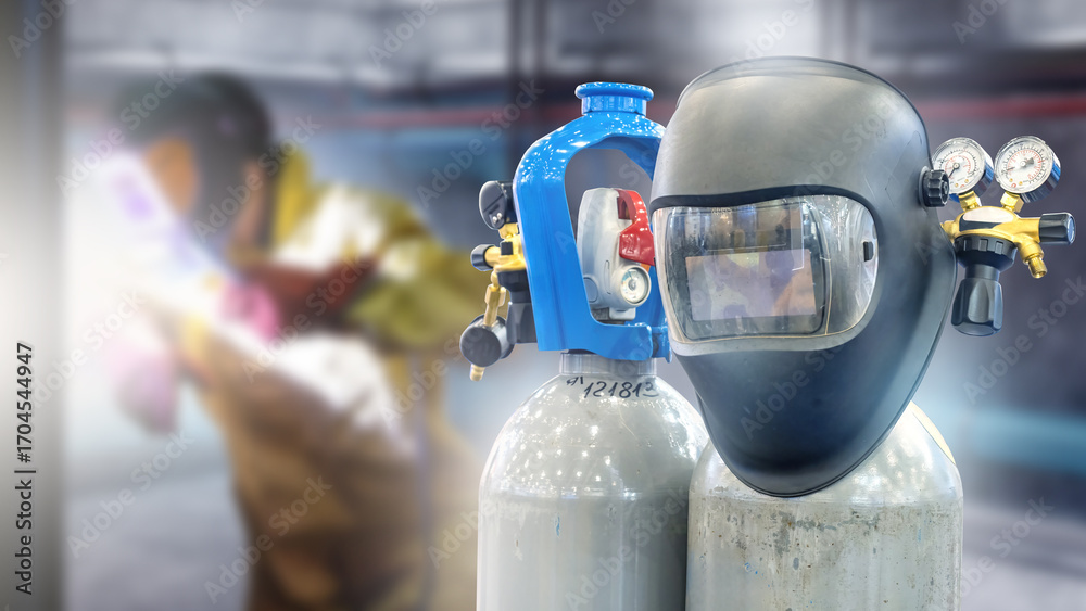 Fototapeta premium Welding mask and gas cylinders with gauges in workshop, welder working in background, metal fabrication, industrial welding, manufacturing, engineering.
