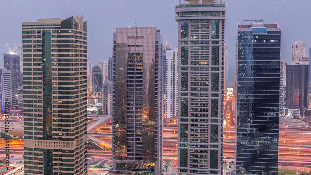 Obraz premium Residential and office buildings in Jumeirah lake towers district night to day timelapse in Dubai