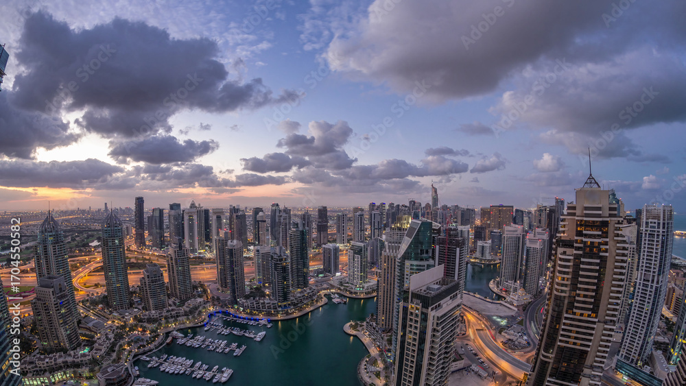 Obraz premium Dubai Marina skyscrapers and jumeirah lake towers view from the top aerial night to day timelapse in the United Arab Emirates.