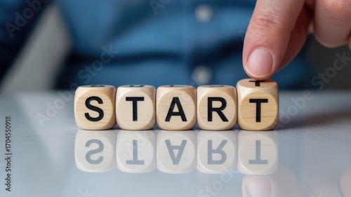Hand placing final letter cube to spell START, symbolizing new beginnings and project launch