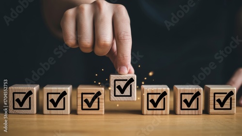 Hand selecting a checked box from a row of wooden cubes, representing decision-making and task completion.