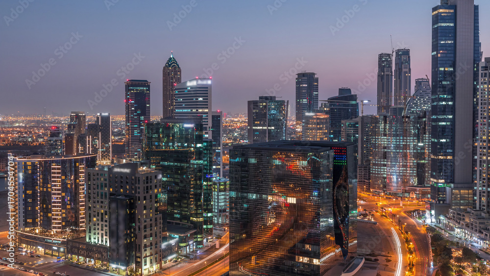 Obraz premium Dubai's business bay towers at evening aerial day to night timelapse.