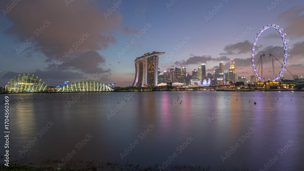Obraz premium Downtown skyline of Singapore as viewed from across the water from The Garden East day to night timelapse. Singapore.