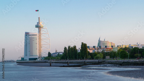 Slika na platnu Hotel Tower in the Park of the Nations at sunset with ebb-tide timelapse