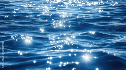 Bright sunlight reflecting off calm blue ocean water creating sparkling glimmers