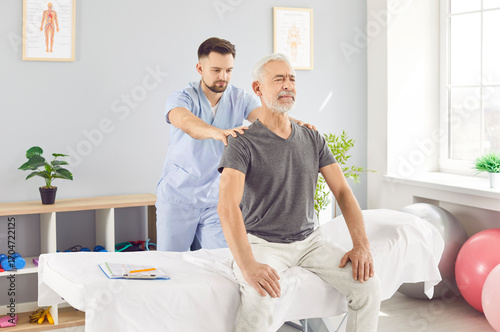 Cuadro en lienzo Doctor physiotherapist performs a back massage for an senior patient during a rehabilitation session