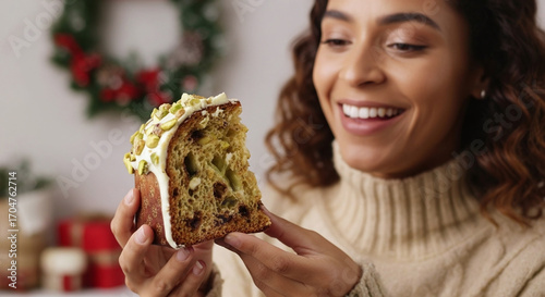 Joyful woman savoring delicious pistachio panettone slice, celebrating festive holiday season with warmth and delight