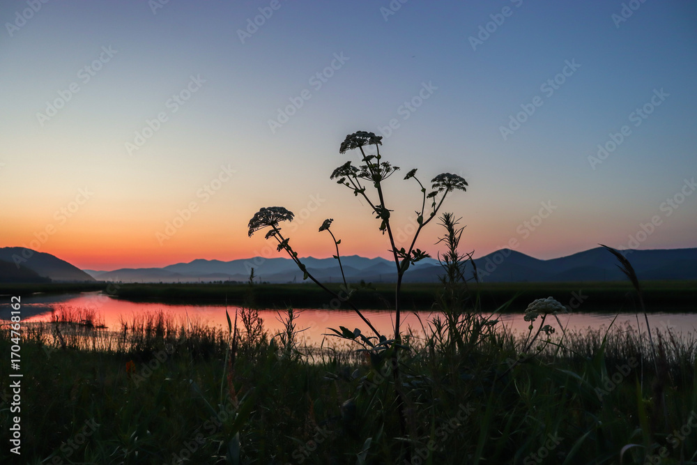 Obraz premium Beautiful sunset over the river. Traveling through wild places. Taiga.