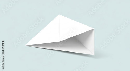 Origami paper boat floating on a light blue surface, showcasing the simple yet elegant design