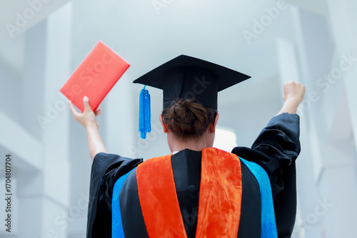 Back view of graduates celebrating their college graduation with pride and joy on graduation day. Congratulations.