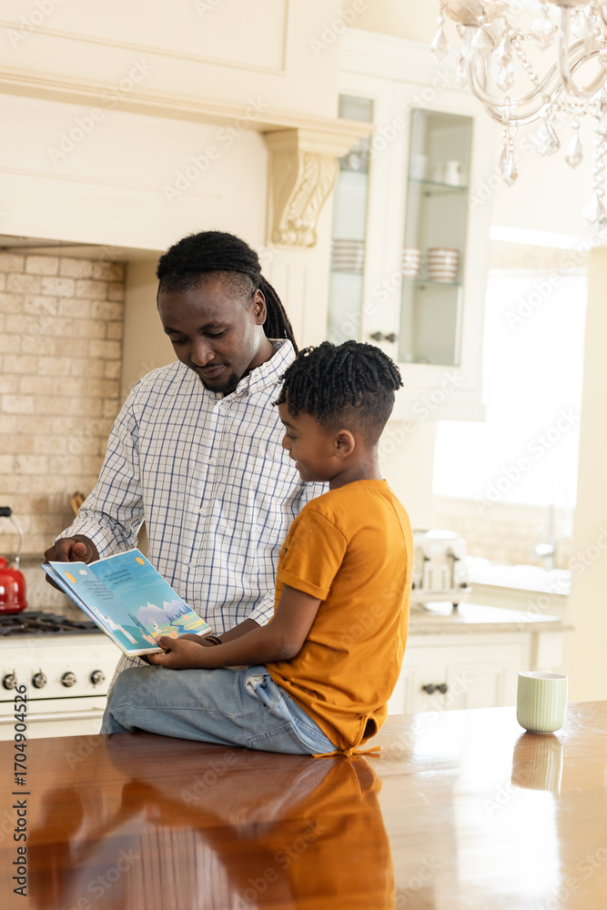Obraz premium African American father reading storybook to son in cozy kitchen setting