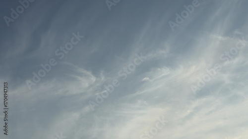 The blue sky is decorated with a sprinkling of thin white clouds.