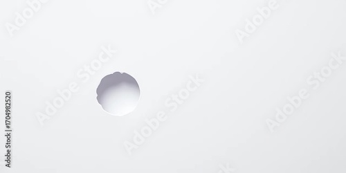 A small, perfectly round hole punched in a sheet of white paper,  design,  scrapbooking