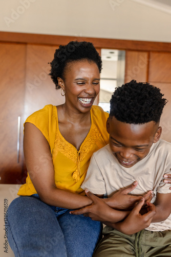 Mother and son laughing together at home, sharing joyful family moments