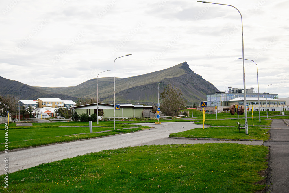 Fototapeta premium Quiet suburban landscape with mountain scenery in Akranes, Iceland under overcast sky