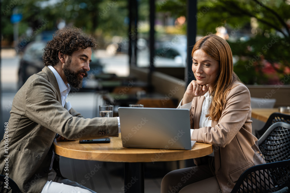 Fototapeta premium Business people working on laptop at outdoor cafe