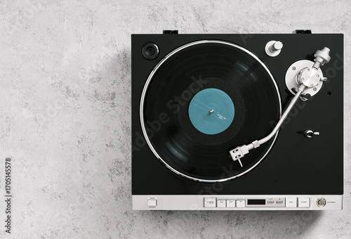 фотографія Vintage turntable playing a vinyl record on a gray background