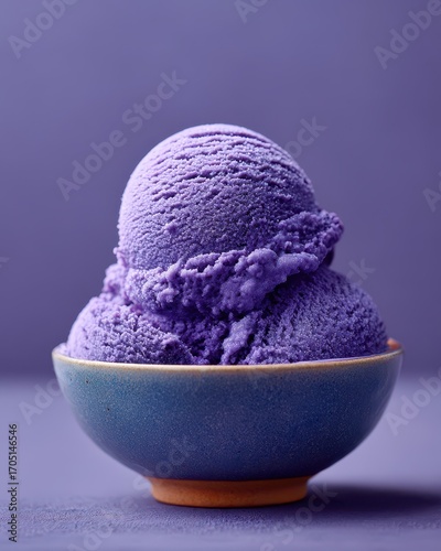 Close-up of two scoops of vibrant purple ice cream in a blue bowl