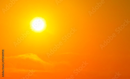 Strong sunlight shining in the orange golden yellow sky. Heat wave in the summer.