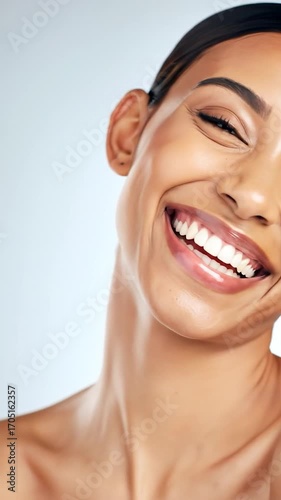 Close-up of smiling woman's face against a plain backdrop