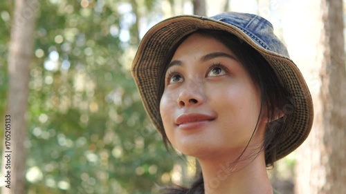 Pretty young Asian woman feeling peaceful while enjoying the forest scenery and environment.