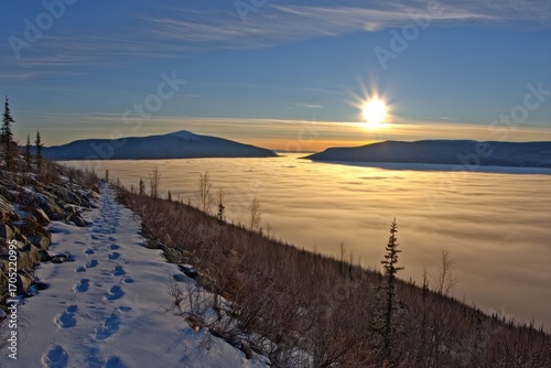 Footprints on Snowy Trail Overlooking Foggy Valley at Sunrise winter path