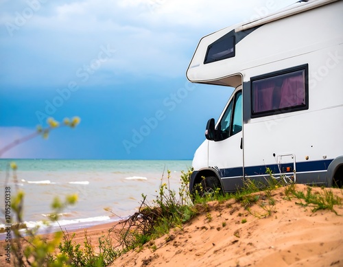 White campervan parked on sandy beach near ocean