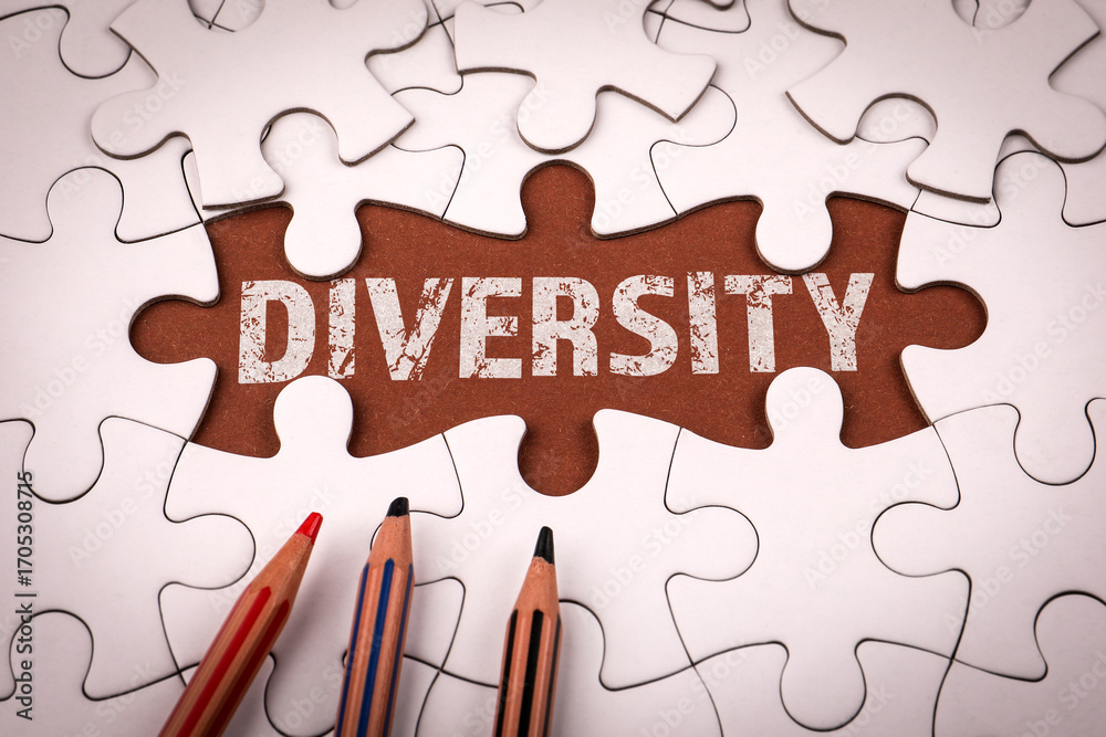 Fototapeta premium Word diversity revealed under missing puzzle piece with colored pencils. Symbolizing inclusion, equality and social unity
