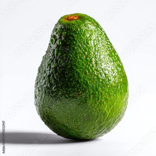 A single, ripe avocado, glistening with water droplets, sits on a white background, casting a subtle shadow