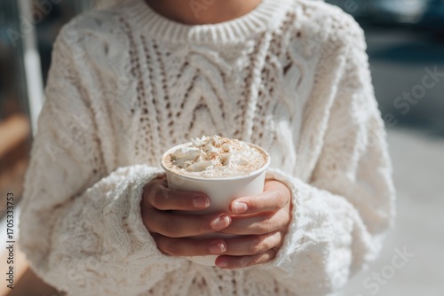 young woman in white sweater holding pumpkin spice latte, soft daylight, minimal thanksgiving café mood