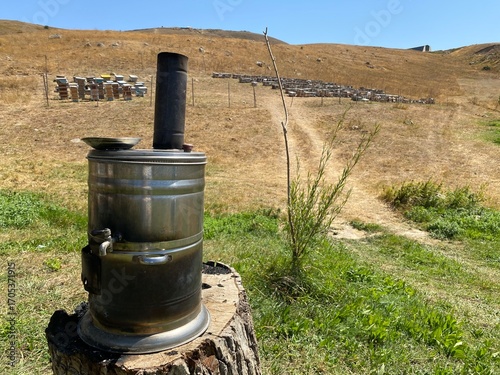 A bee apiary in the mountains and a street samovar on a tree stump