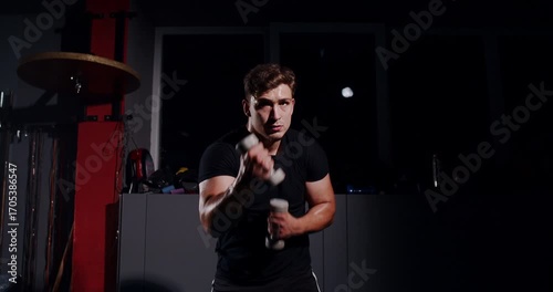 In a dim boxing ring, a determined man showcases his skills in an intense match